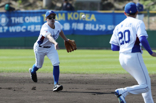 14일 오키나와현 우루마시 구시가와 구장에서 열린 월드베이스볼클래식(WBC) 야구 대표팀 훈련에서 두산 내야수 오재원이 1루로 향하는 투수에게 공을 던지고 있다.  사진=연합뉴스